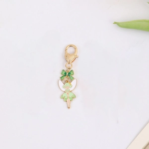 Macro detail of fairy enamel pendant with green dress and heart-shaped lobster clasp