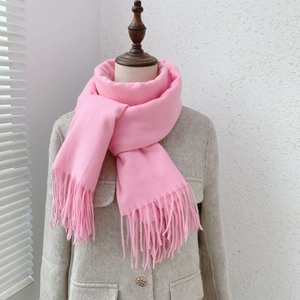 Detail of pink cashmere-like scarf with fringe texture on a mannequin neck