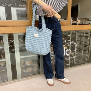 Dettaglio della borsa tote azzurra con texture a bolle con morbido tessuto 3D e logo
