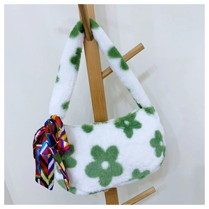 Detail of white plush shoulder bag with green floral pattern and a colorful silk scarf