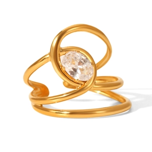 Detail of multi-layered gold ring featuring an oval clear zircon on a polished surface