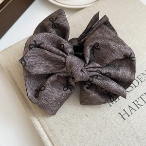 Macro detail of the fabric texture and bow pattern on the premium hair claw clip