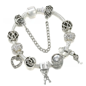 Detailed macro view of silver-plated snake chain bracelet with heart charms and love pendants