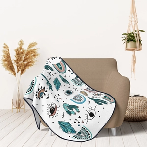 Detail of bohemian flannel blanket with evil eye and cactus patterns on armchair