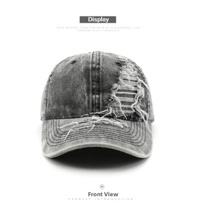 Macro detail of retro washed grey denim baseball cap with distressed ripped fabric texture