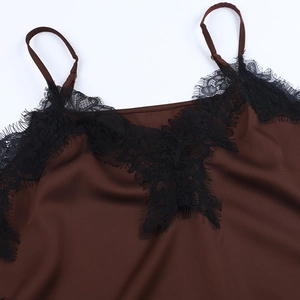 Gros plan sur la dentelle du décolleté en V et le satin café du caraco