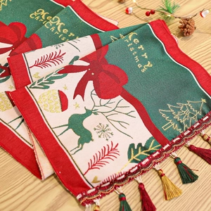 Detail of Christmas table runner with Merry Christmas jacquard weave and festive tassels