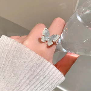 Detailed close-up of a silver butterfly ring with sparkling gradient crystal texture