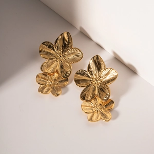 Elegant gold double flower earrings in stainless steel with a brushed metal texture