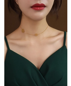 Detailed view of hollow rose necklace in 18K gold plated titanium steel on a model neck