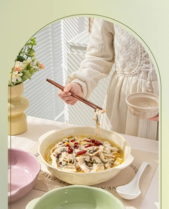 Detailed view of large ceramic soup bowl with double handles in a warm dining setting