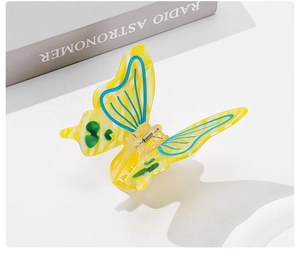 Close-up of butterfly acetic acid hair claw with yellow and blue patterns