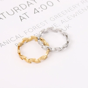Minimalist 18k gold and silver stainless steel leaf vine rings on card background