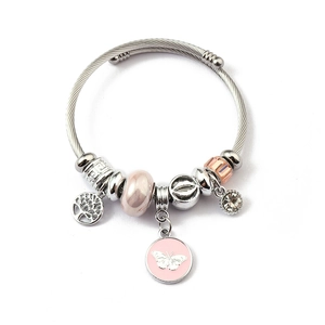 Detail of silver woven bracelet with pink enamel butterfly and tree of life charms