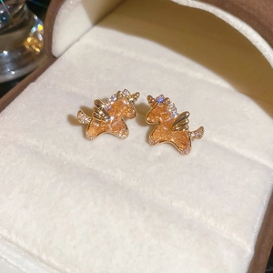 Macro view of 18k gold plated unicorn earring with amber crystal and zircon in a box