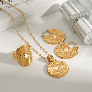 Detail of gold-tone jewelry set featuring concentric circles and sparkling gems