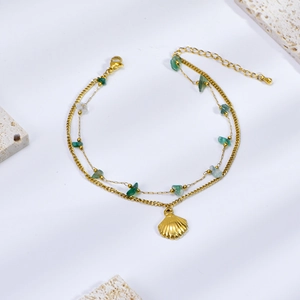 Detail of double-layer titanium steel anklet with green stones and shell charm