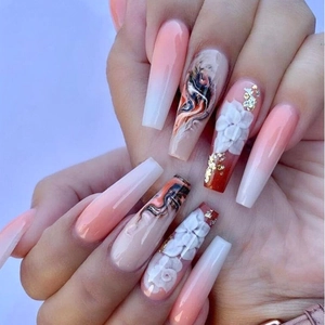 Detail of long coffin nails with pink gradient, marble texture, and 3D floral accents