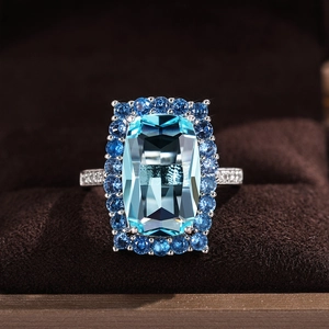 Bague de mariage élégante avec zircon bleu rectangle et halo sur fond de velours
