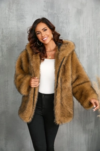 Détail d'une veste à capuche en fausse fourrure marron montrant la texture épaisse