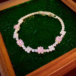 Detail of pink square gemstone bracelet with gold finish and fold-over clasp closure