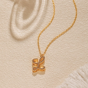 Close-up of gold 18K plated necklace with sparkling crystal letter L cursive pendant