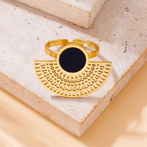 Golden fan-shaped stainless steel ring with black round inlay on a natural stone base