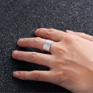 Polished silver stainless steel wide band ring shown on a model hand with macro detail