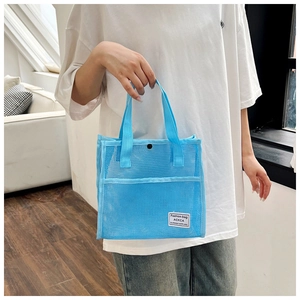 Detail of blue mesh tote bag showing breathable fabric texture and secure snap closure