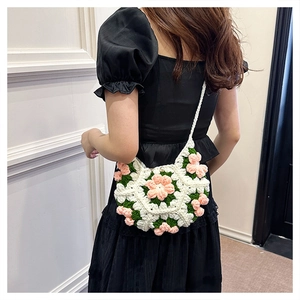 Detail of handmade crochet puff flower crossbody bag with pearl button and floral texture