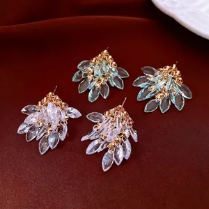 Elegant diamond-shaped zircon tassel stud earrings set on a silk fabric background