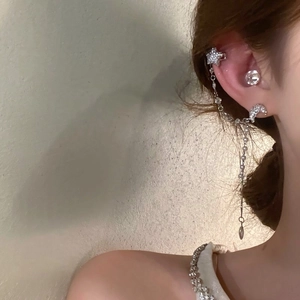 Close-up detail of integrated star and moon ear cuff with elegant dangling rhinestone tassels