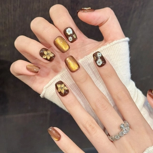 Brown and gold cat-eye press-on nails with 3D floral accents and vintage metal textures