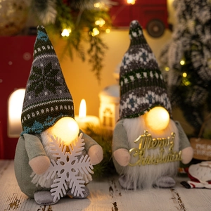 Nahaufnahme leuchtender Weihnachtswichtel mit Schneeflocke und Merry Christmas Schild