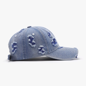 Distressed light blue denim baseball cap with frayed holes and vintage curved brim style