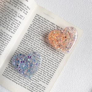 Detailed macro view of heart-shaped glitter phone grips in orange pink and blue violet