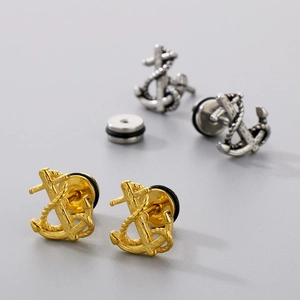 Dettaglio macro di orecchini a perno a forma di ancora in oro e argento vintage
