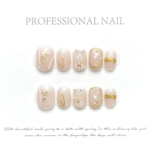 Close-up of pink press-on nails with gold foil, 3D butterfly, and hand-painted art