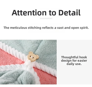 Detail of coral fleece hair towel featuring a bear wood button and white piping edge