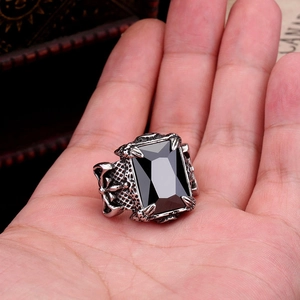Detailed macro view of retro gothic ring featuring a black gem and dragon claw relief