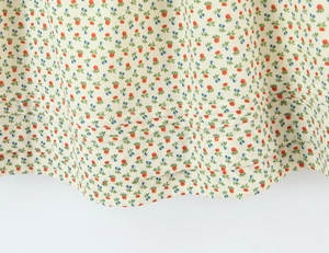 Detailopname van de jurkzoom met bessenprint en decoratieve horizontale plooien