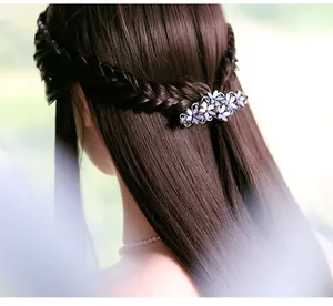 Detail of vintage flower hair clip with rhinestones worn on elegant wavy hair