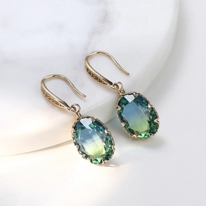 Detail of gold oval earrings with teal gradient gemstone and micro-pave cubic zirconia