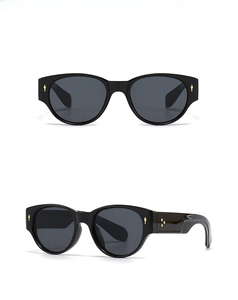 Close-up of black retro sunglasses with classic gold arrow and flower cluster rivets