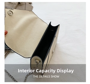 Detail view of the spacious inner compartment of this cream chain crossbody bag