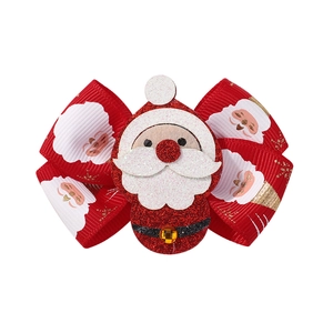 Détail d'une pince à cheveux de Noël rouge avec Père Noël pailleté et nœud imprimé