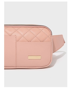 Close-up of a pink quilted faux leather waist bag with a gold metal plate detail