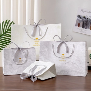 Elegant marble pattern gift bags with ribbon handles in various sizes for celebrations