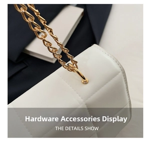 Detail of the high-shine gold chain strap and quilted white leather finish on the bag