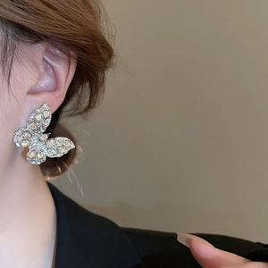 Dettaglio di orecchini a perno a farfalla in argento con cristalli taglio marquise